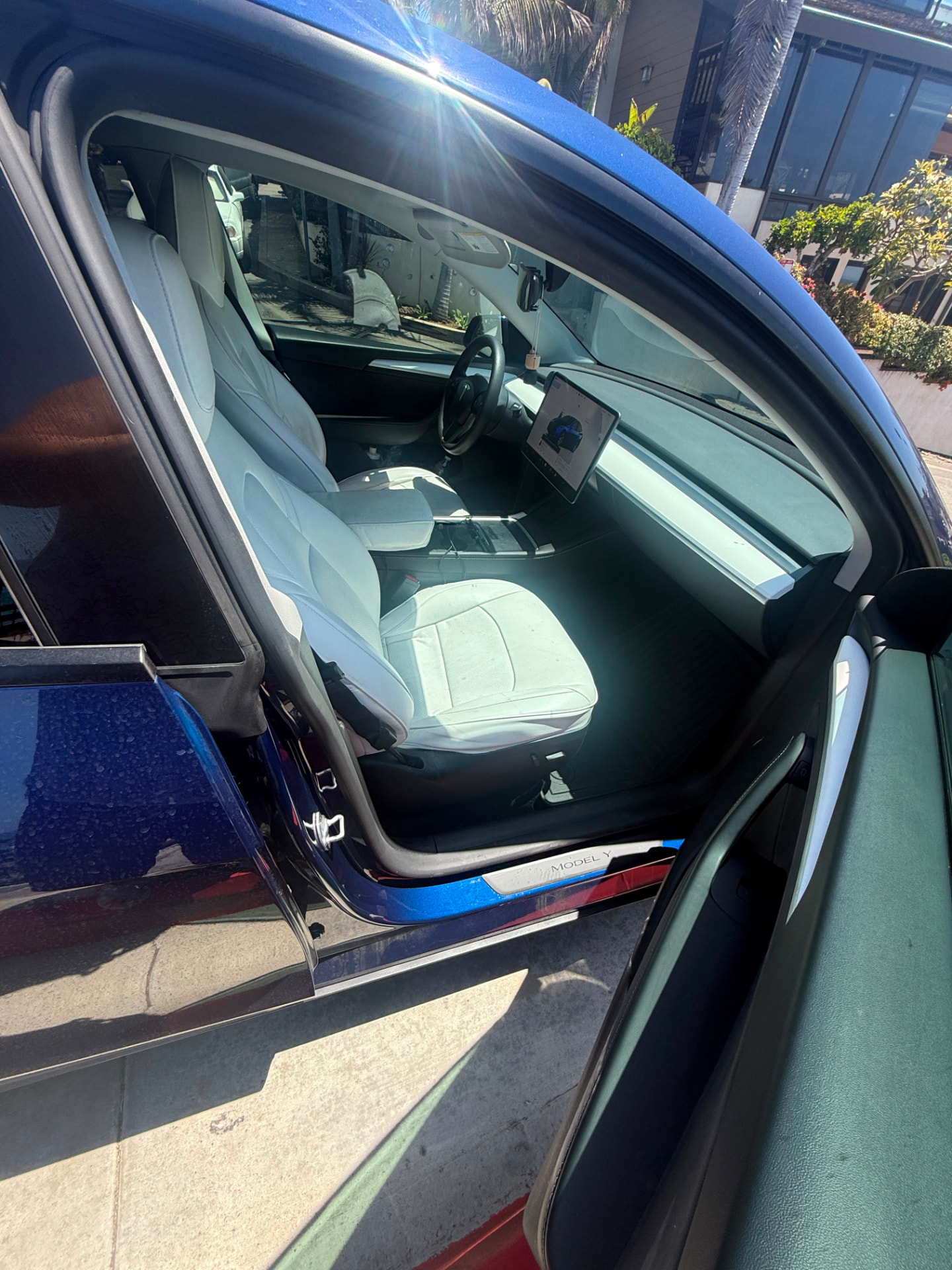 Driver area with the Tesla touchscreen and white seats